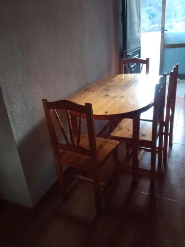 伊科德洛斯维诺斯Casita con vista a la montaña的一张带两把椅子的木桌、一张木桌和一张桌子及椅子。