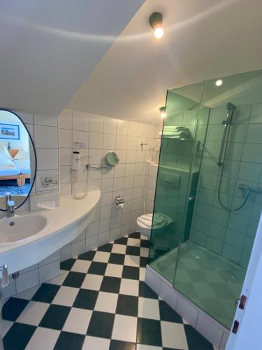 玛丽亚韦尔特Hotel Seewirt的一间带玻璃淋浴和水槽的浴室