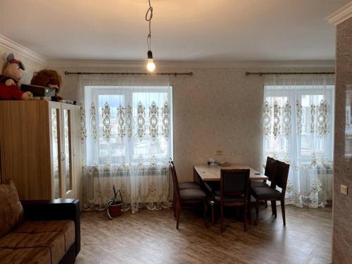塞凡Aram Guest House的客厅配有桌椅和窗户。