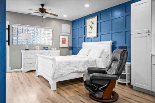 凤凰城Chelsea Place的蓝色的卧室配有白色的床和黑椅