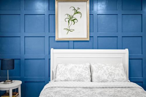 凤凰城Chelsea Place的卧室拥有蓝色的墙壁和白色的床。