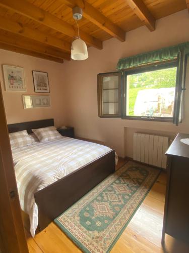 因菲耶斯托CASA LUISA Biedes, Piloña的一间卧室设有床、窗户和地毯。