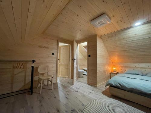 U Progu Lasu的一间卧室设有一张床和木墙