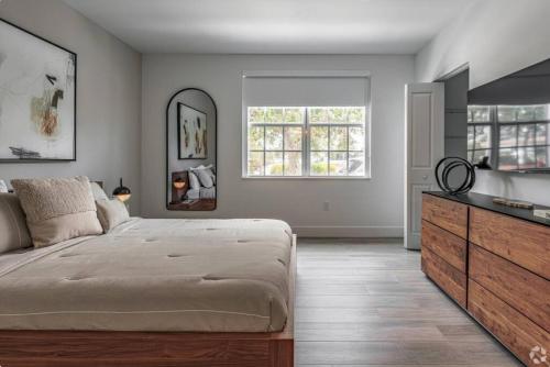 沃思湖Gardenia - The Designer Apartment的一间卧室配有一张大床和一个梳妆台