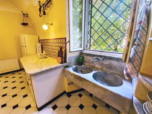 萨尔扎纳Villa De Benedetti的一间带两个盥洗盆和窗户的浴室