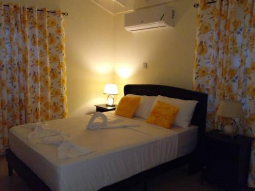 法尔茅斯Ital Vibes Get Away的一间卧室配有带橙色和白色枕头的床