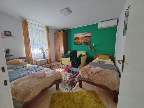 KaranacARKI, KUĆA ZA ODMOR的一间卧室设有两张床和绿色的墙壁