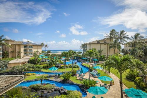 卡帕阿Waipouli Beach Resort and Spa Kauai by OUTRIGGER的享有带游泳池和遮阳伞的度假村的空中景致