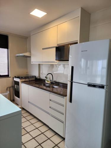 里约热内卢Apartamento completo的厨房配有白色橱柜和白色冰箱。