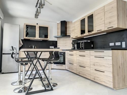 贡比涅Chambre Evasion - SDB WC Privatif - Entrée autonome - Grande TV NETFLIX的厨房配有木制橱柜和桌子