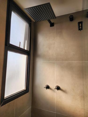 里约热内卢Apartamento completo的带淋浴的浴室,配有2个水龙头和窗户