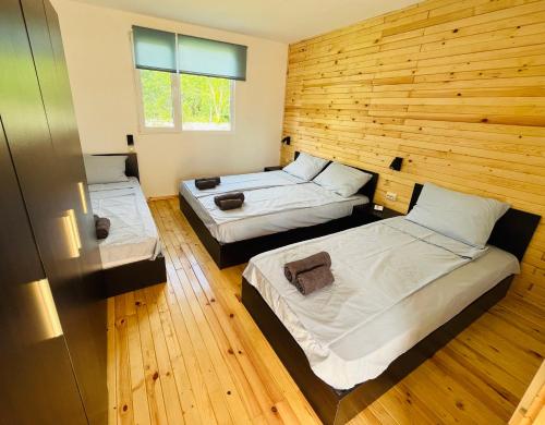 切尔诺莫雷茨CozyHut Бунгало под Наем的客房设有两张床和木墙
