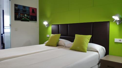 伊维萨镇Huéspedes Sa Font的卧室配有白色大床和绿色墙壁