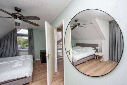 泰尔霍讷Vakantiehuis Bongel 1, Ter Herne的一间带镜子和床的卧室以及楼梯