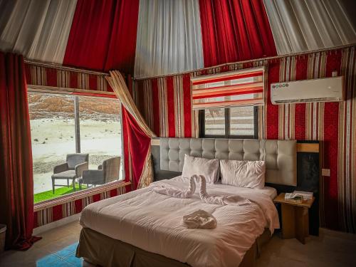 瓦迪拉姆Tower Rum Camb的一间卧室配有一张带红色窗帘的床和一扇窗户