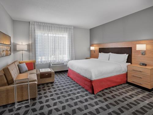 舍伍德帕克TownePlace Suites by Marriott Edmonton Sherwood Park的酒店客房设有一张大床和一张沙发。
