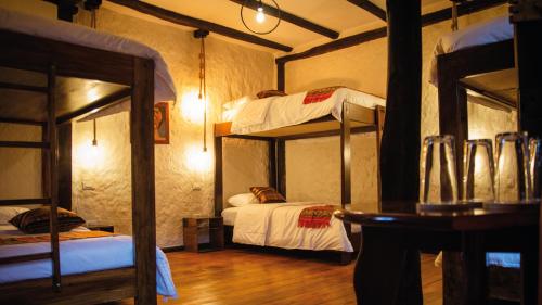 昆卡希加尔餐厅旅馆的客房设有两张双层床和一张桌子。