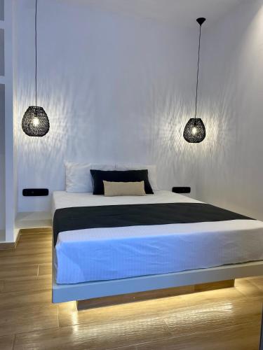 纳乌萨Asteras Cozy Stay的一间卧室配有一张带两个灯的床