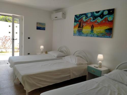 加利波利Vele del Pizzo - piscina的一间卧室设有两张床,墙上挂着一幅画
