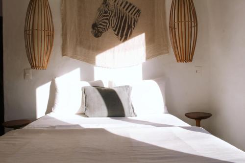 Praia de SantiagoNai的卧室配有一张墙上斑马头的床