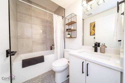 埃德蒙顿Luxe New York Style Bsmt Suite, Near DT & WEM, King Bed, WiFi的白色的浴室设有卫生间和水槽。
