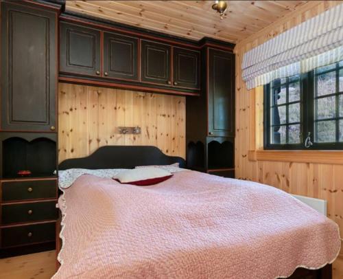 贝特斯托尔Leilighet sentralt på Beitostølen的一间卧室配有一张带粉色毯子的床