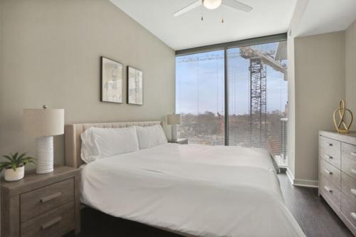 亚特兰大Piedmont Park 2 bdrm的卧室设有一张白色大床和一扇窗户。