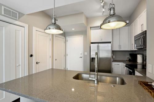 亚特兰大Piedmont Park 2 bdrm的厨房配有不锈钢水槽和白色橱柜
