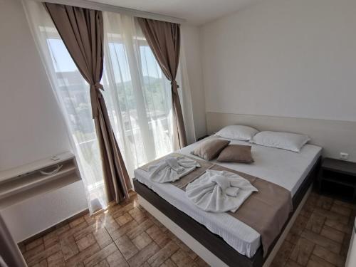 茨雷沃Arapya Apartments的一间卧室设有一张大床和一个大窗户