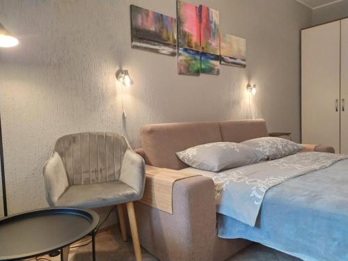 基辅Great view apartaments near Lavra的一间卧室配有一张床、一把椅子和一张桌子