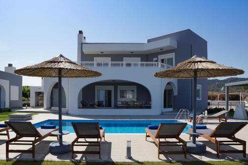阿凡杜Villa Arco Bianco的别墅配有游泳池、椅子和遮阳伞
