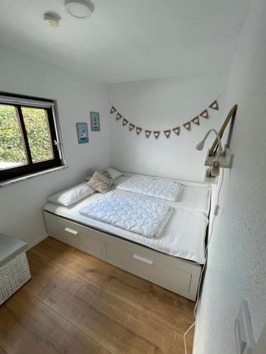 沙博伊茨Haffkrug Beach Bungalow的卧室配有一张带墙壁上横幅的床