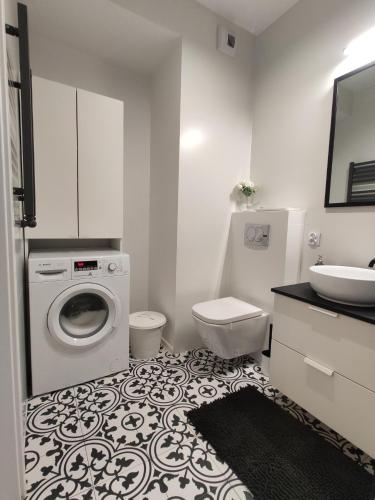 克拉科夫Nowoczesny apartament dla par的白色的浴室设有洗衣机和水槽。