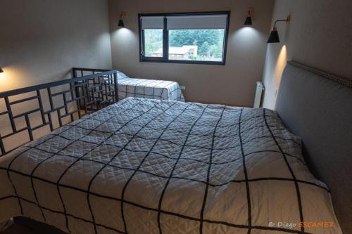 拉安戈斯图拉镇Departamento Lake Soul Villa La Angostura的一间卧室设有一张大床和一个窗户。