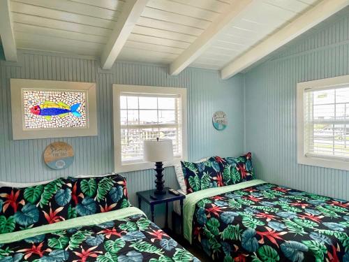 格兰德艾尔布鲁多菲乡村别墅的一间卧室设有两张床和两个窗户。