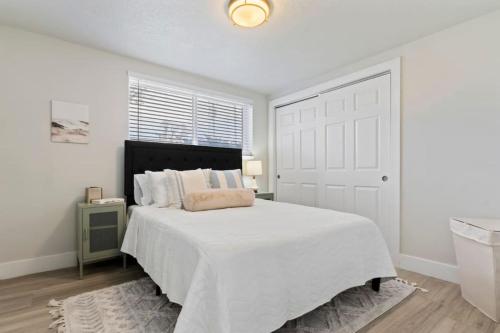 South Salt LakeAmazing New Condo Great Location ! Sugarhouse的白色的卧室设有一张大床和一个窗户