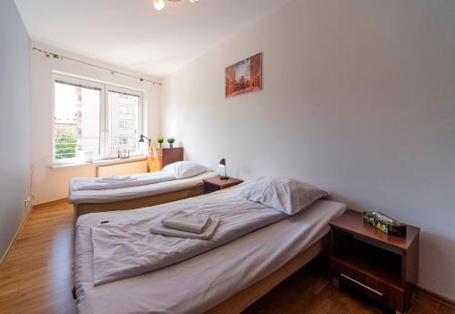 罗兹Lodz4u - Premium Apartment - PIOTRKOWSKA - Garaż - Swiatłowód的带窗户的客房内设有两张单人床。