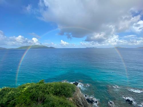 Tortola IslandThe Aerial, BVI All-Inclusive Private Island的两只彩虹在海洋上方,海岸岩石 ⁇ 