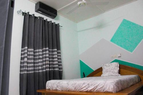 博博迪乌拉Ranya的一间卧室配有床和黑色窗帘