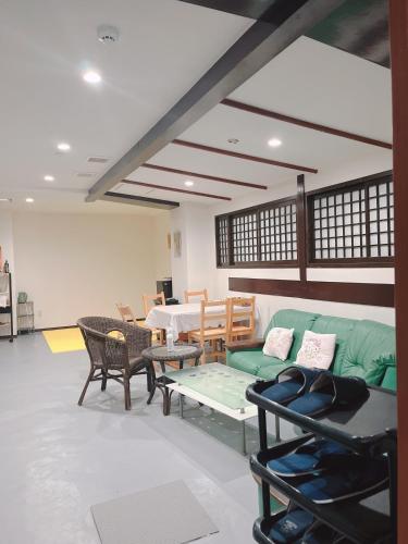 长崎ひまわりHotel的客厅配有绿色沙发和桌子