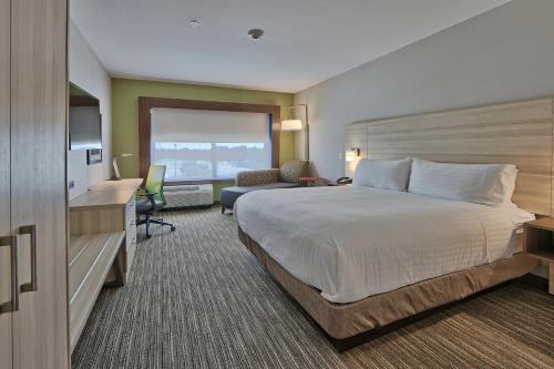 罗斯威尔罗斯威尔智选假日套房酒店的酒店客房设有一张大床和一张书桌。