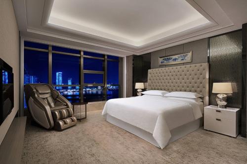 南昌南昌喜来登酒店的一间卧室设有一张大床和一个大窗户