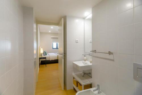 波尔图Porto Downtown Living - Picaria Apartments的一间带水槽和卫生间的浴室以及一间卧室