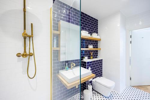 伦敦Apartment Near Canary Wharf 02 Arena & Excel的蓝色瓷砖浴室设有水槽和卫生间