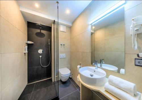 辛德尔芬根Hotel Business Bay das ehemalige Staycation Hotel的一间带水槽、淋浴和卫生间的浴室