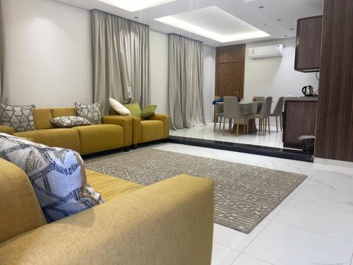 巴勒如拉斯فلل بيات الفيصل Bayat Al Faisal Villas的一间带黄色沙发的客厅和一间用餐室