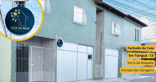 蒂安瓜Casa da Maia Hostel的带有门和标志的蓝色建筑