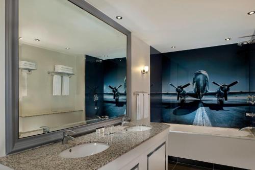 希灵登喜来登希斯罗酒店的一间带两个盥洗盆和大镜子的浴室
