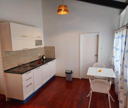克罗托格The Crow's Nest Resort Fiji的厨房配有白色橱柜和桌椅