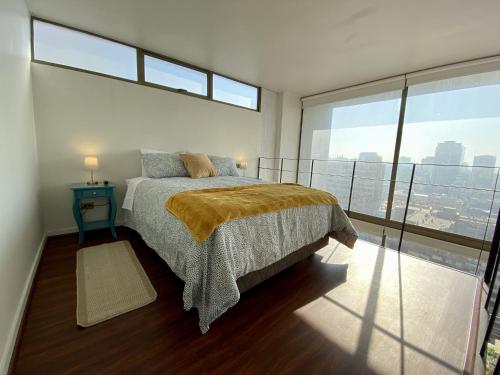 圣地亚哥Loft Smart Panoramico - Santiago的一间卧室设有一张床和一个大窗户